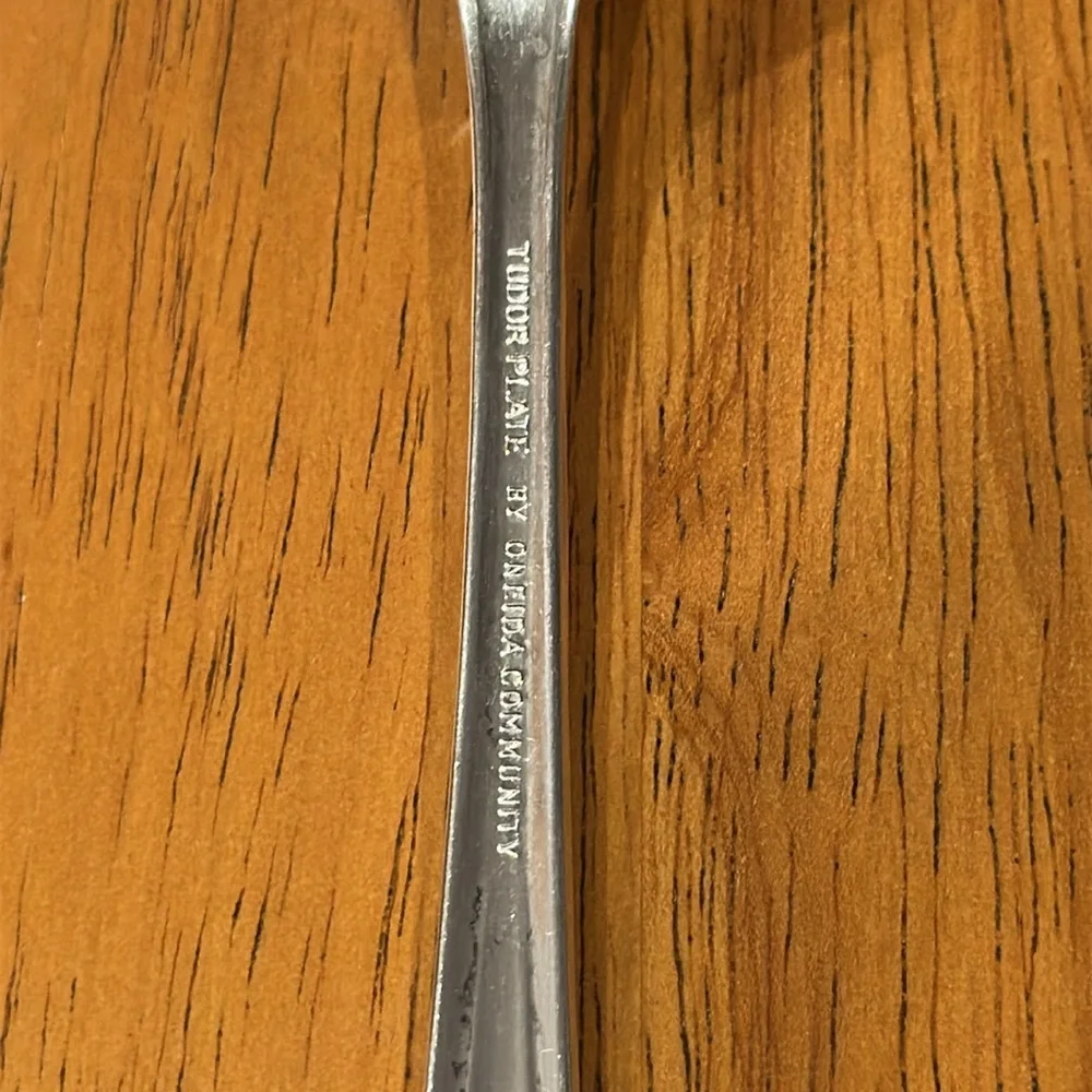 Oneida Tudor plate silver salad fork. Neck is rounded and has a slit edge.
